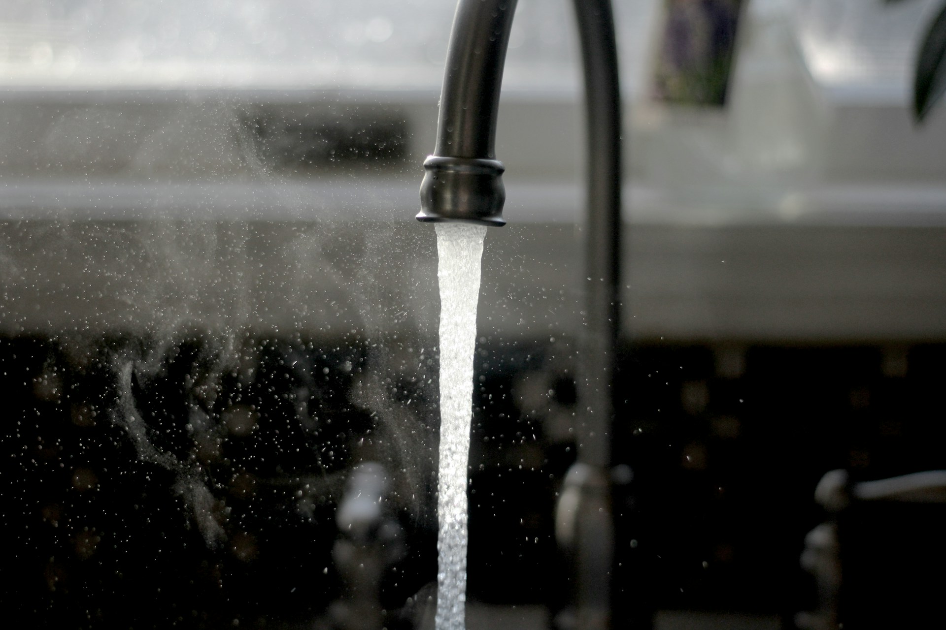Donkergrijze kraan waar water uit stroomt
