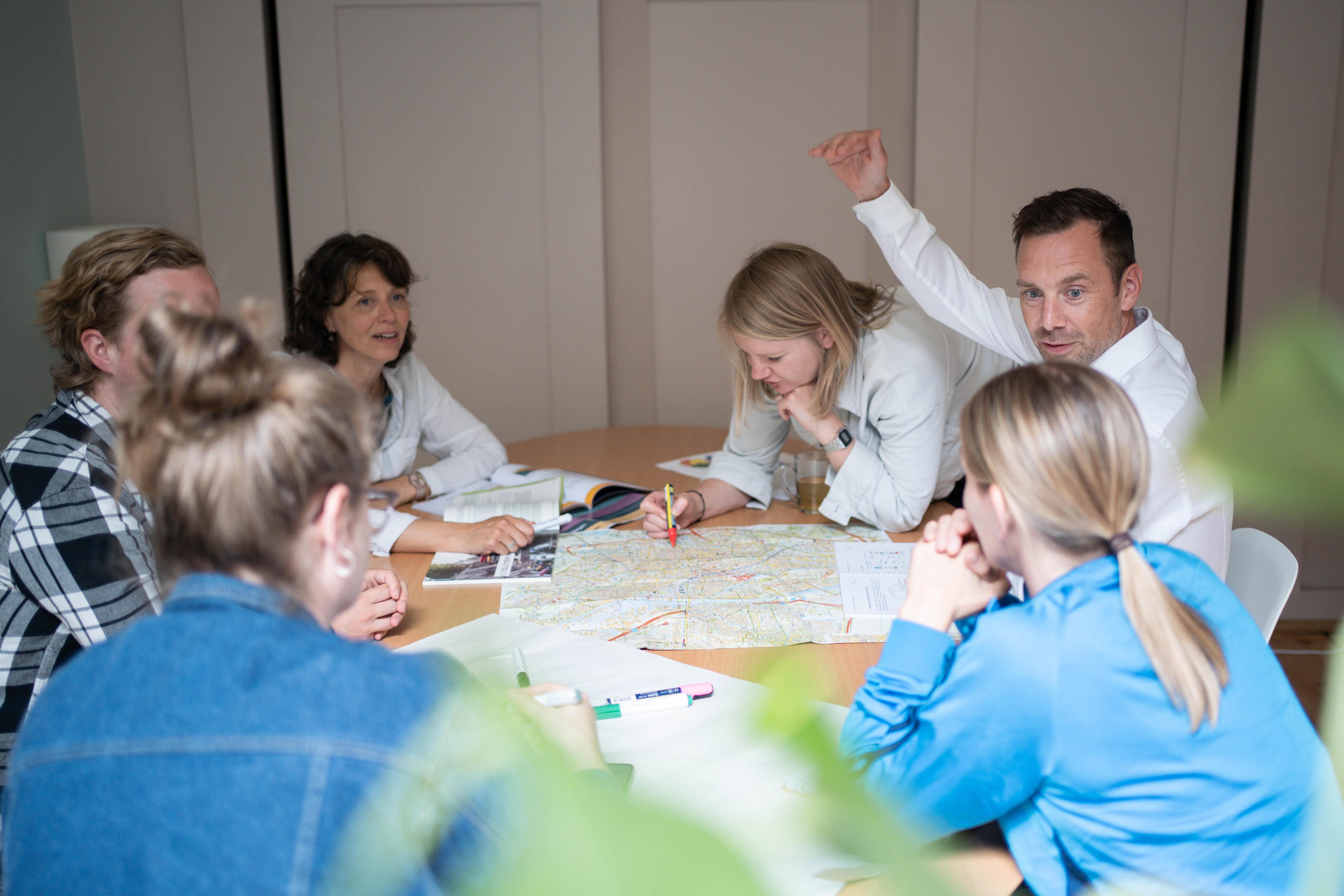 Zes mensen in gesprek rond een tafel