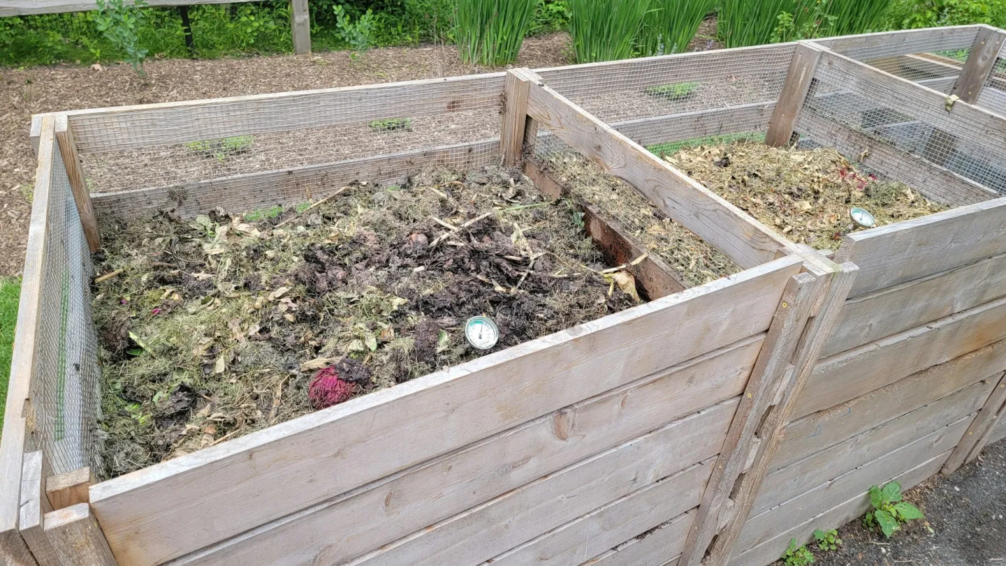 Houten compostbak met daarin tuinafval