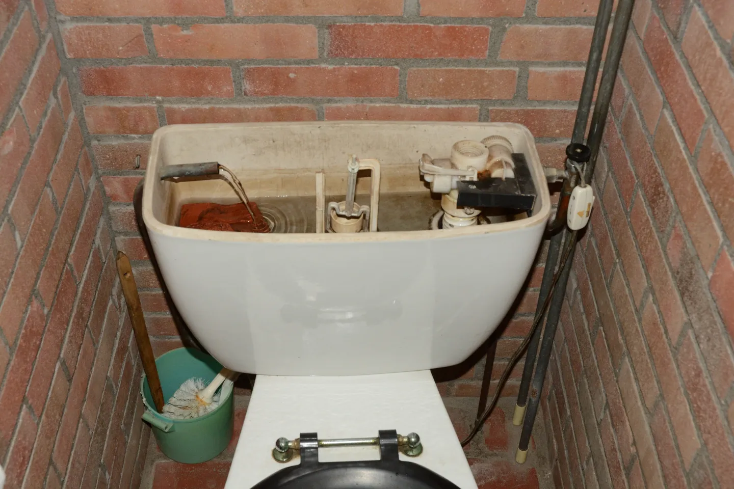 Het waterreservoir van een toilet met de aansluiting op het regenwatersyteem