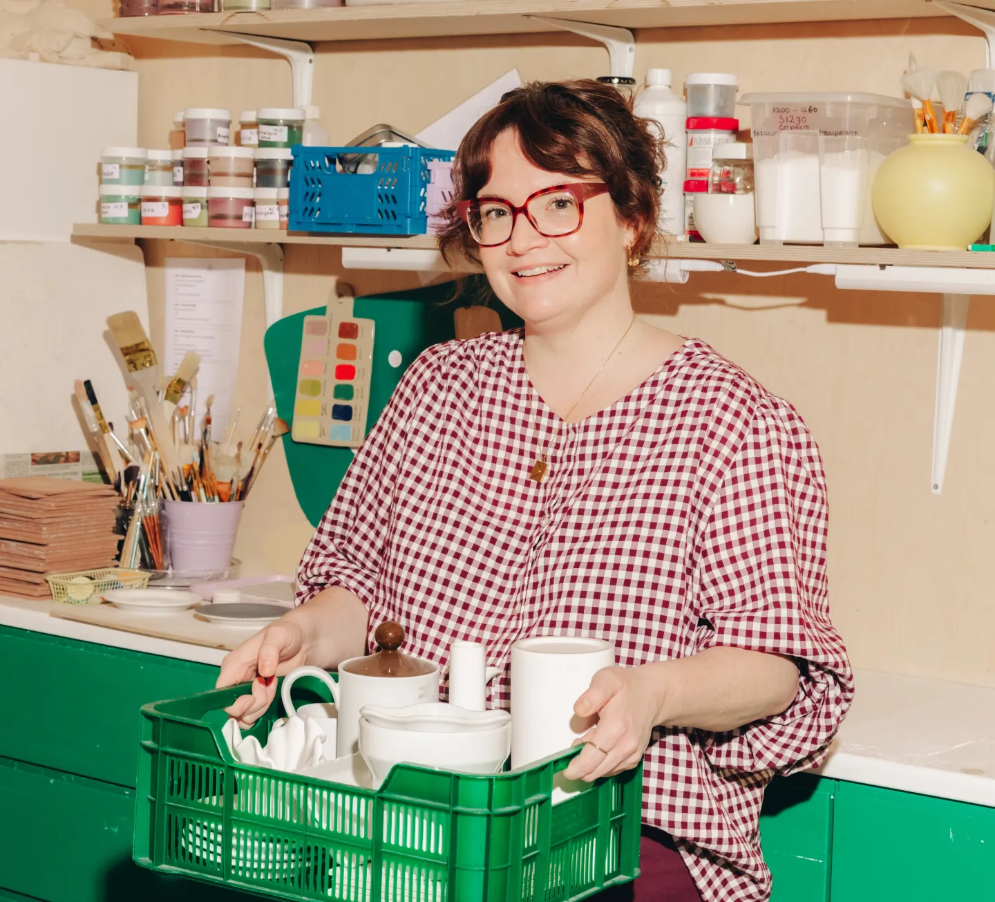 Emma Odenkirchen houdt een groen krat met servies vast