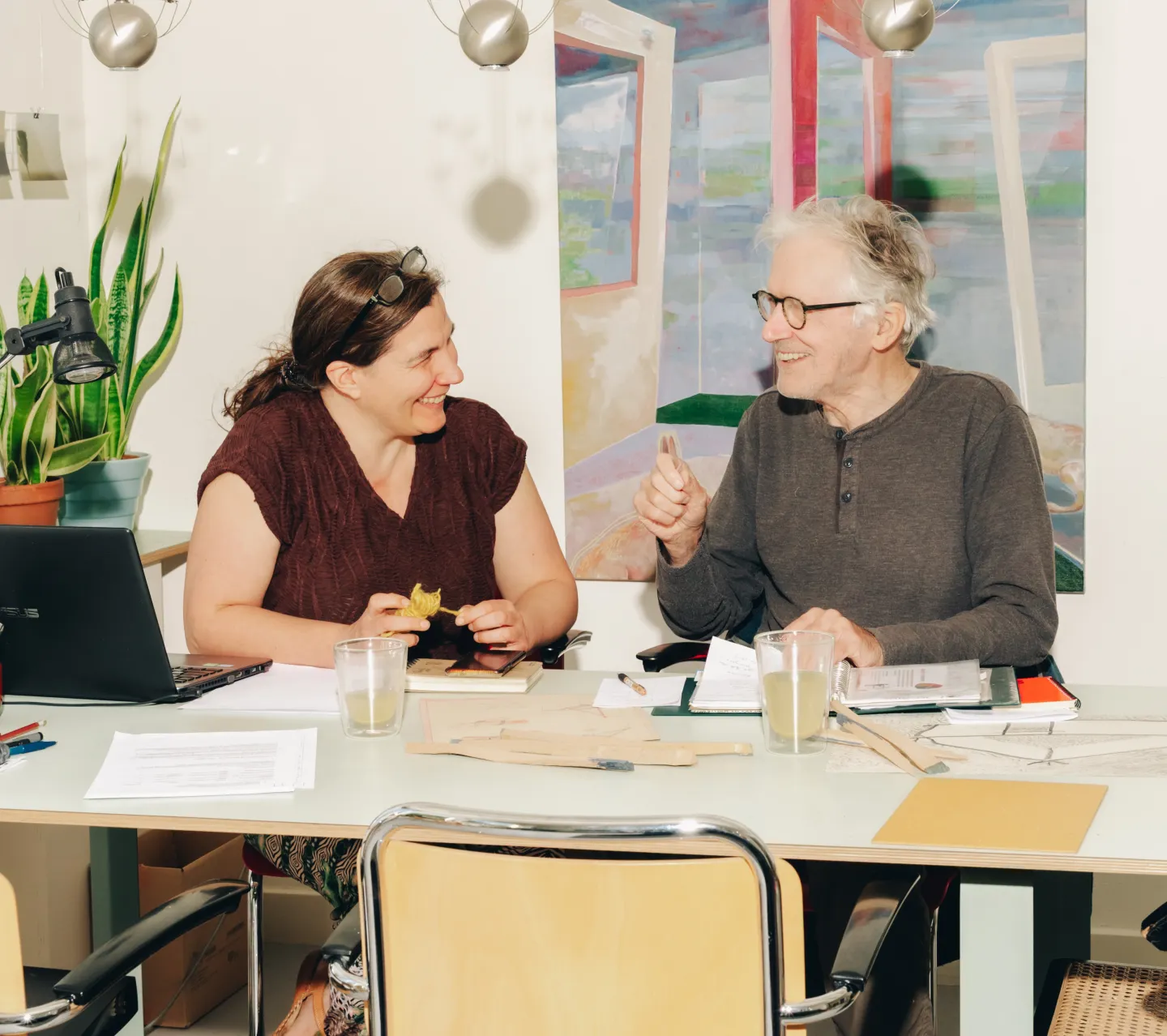 Man en vrouw zitten lachend aan tafel