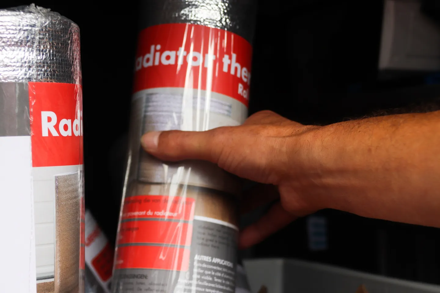 Hand pakt rol radiatorfolie