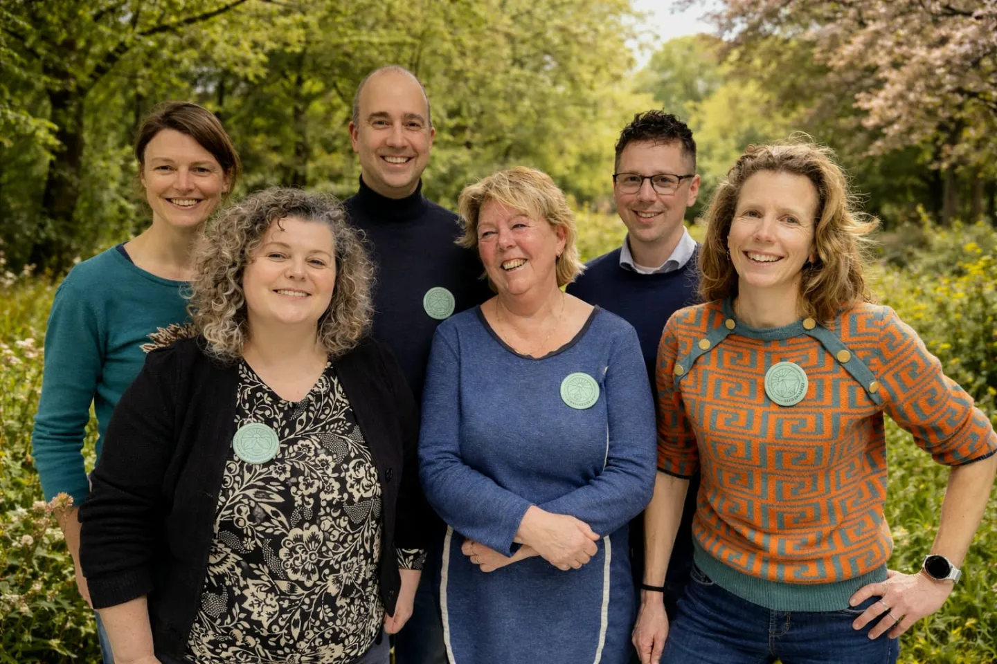 Groep van 6 mensen in een groene tuin
