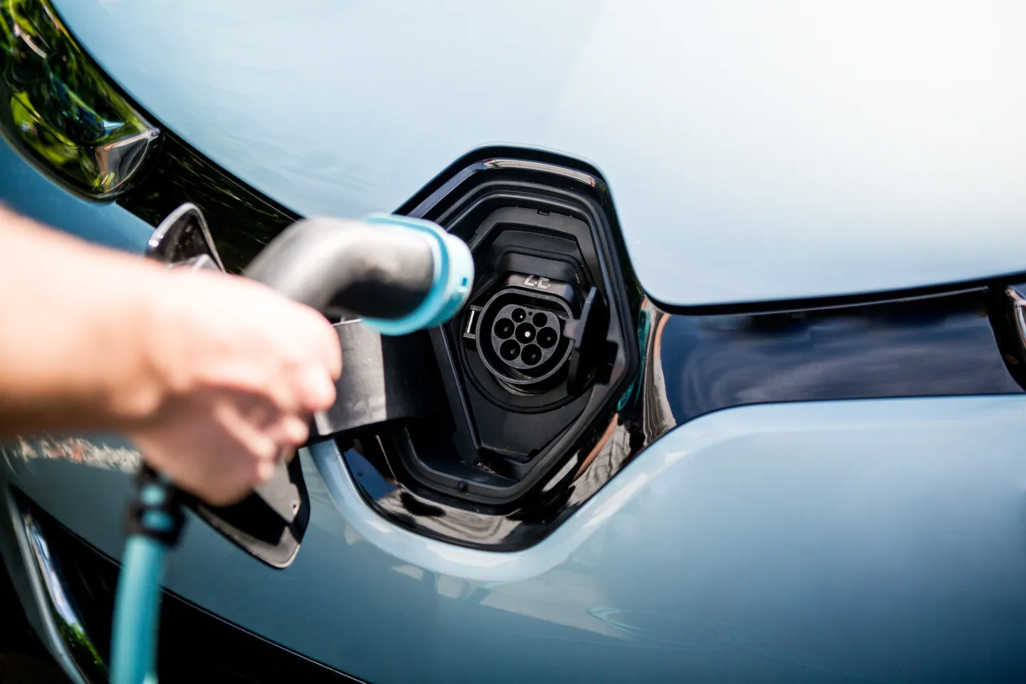 Oplaadstekker wordt aan de voorkant van auto in stekkeropening gedaan