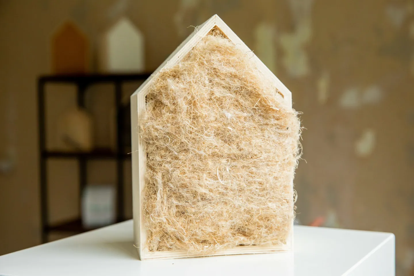 Houten vorm van huisje met daarin beige isolatiemateriaal